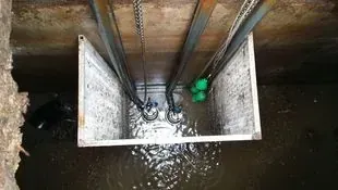 Un desagüe en una pared de hormigón con agua saliendo de él.