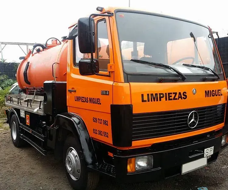 Un camión naranja con la palabra limpieza escrita en el costado.