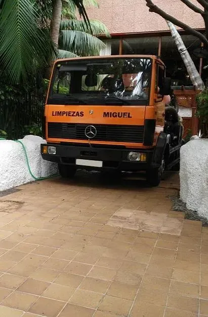 Una máquina está colocada sobre un suelo de baldosas junto a un desagüe.