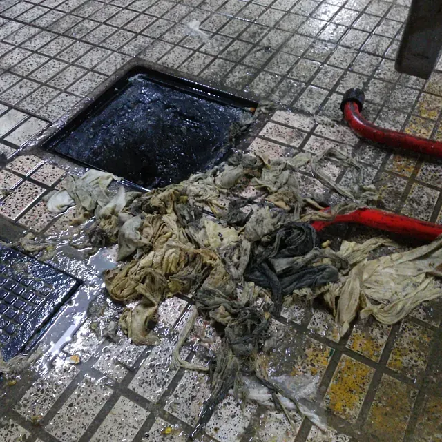 Un agujero en el suelo del que salen muchos desechos.