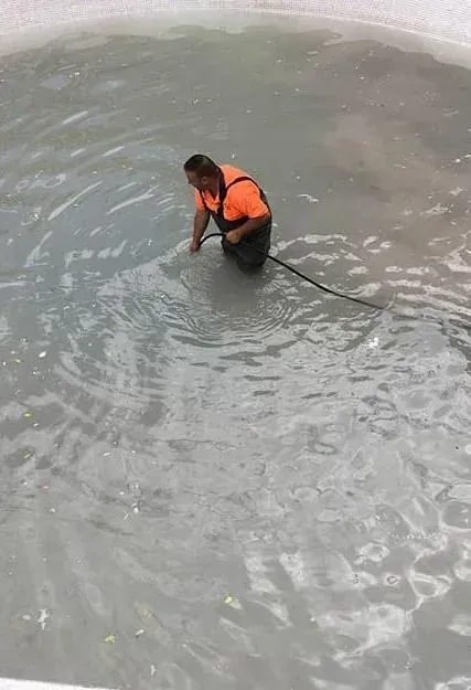 Un limpiador de desagües está sentado en el suelo al lado de una pared.