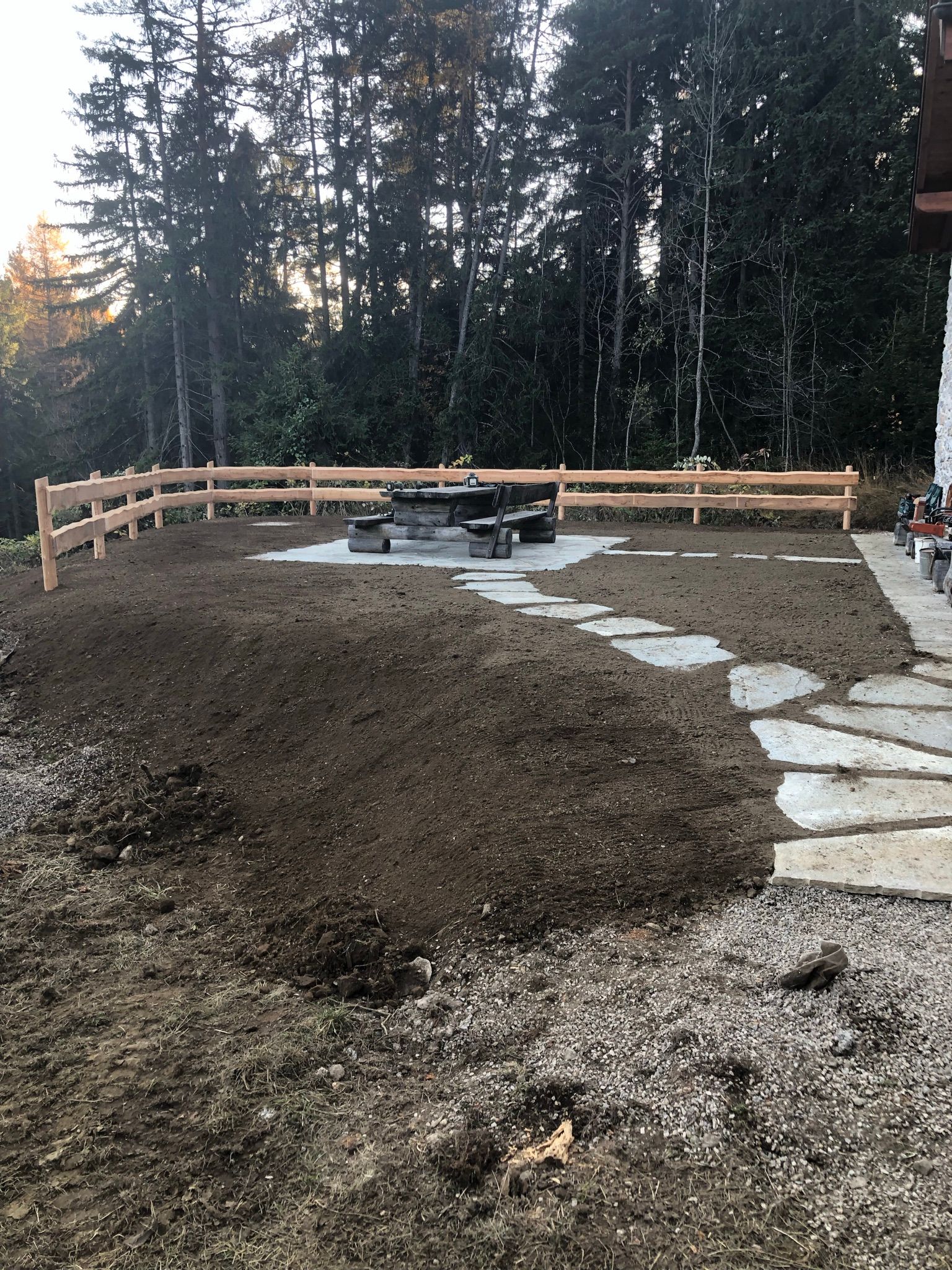 Une cour arrière avec une clôture en bois et une table de pique-nique.