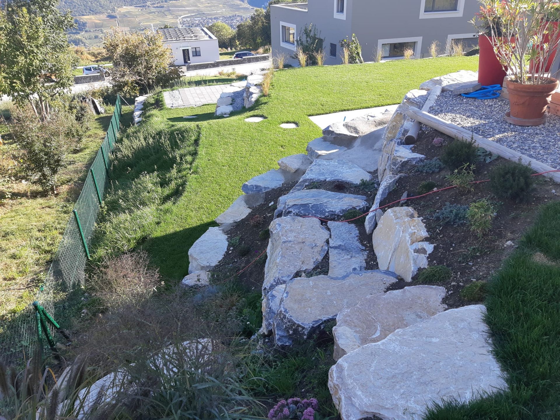 Un mur de pierre avec des marches menant à une maison