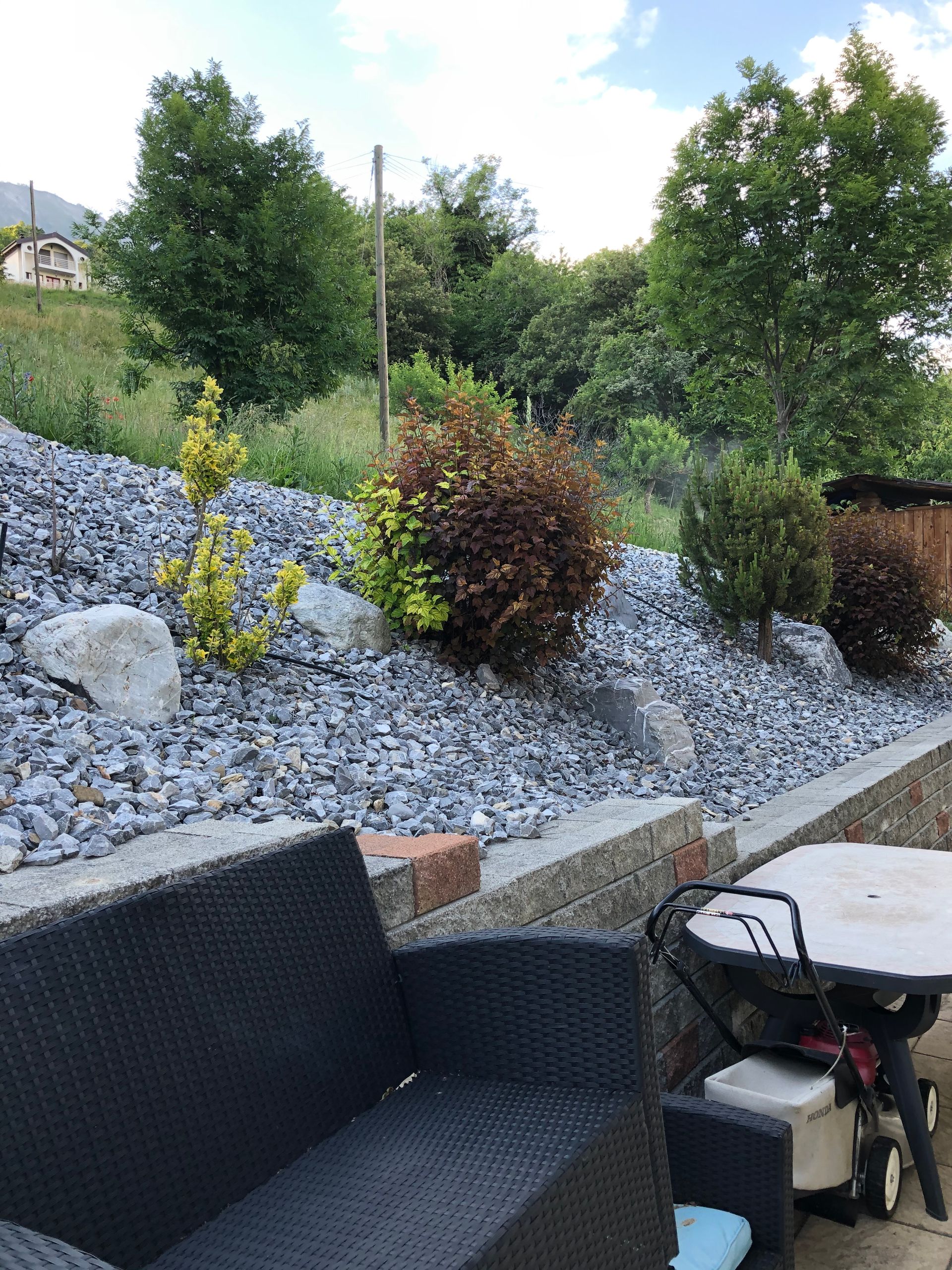 Un canapé et une chaise sont assis sur une terrasse à côté d'une table.