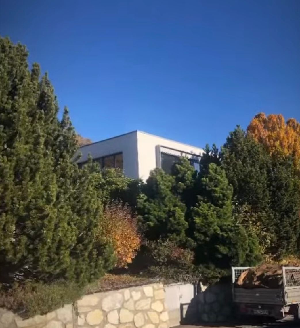 Un camion est garé devant une maison entourée d'arbres.