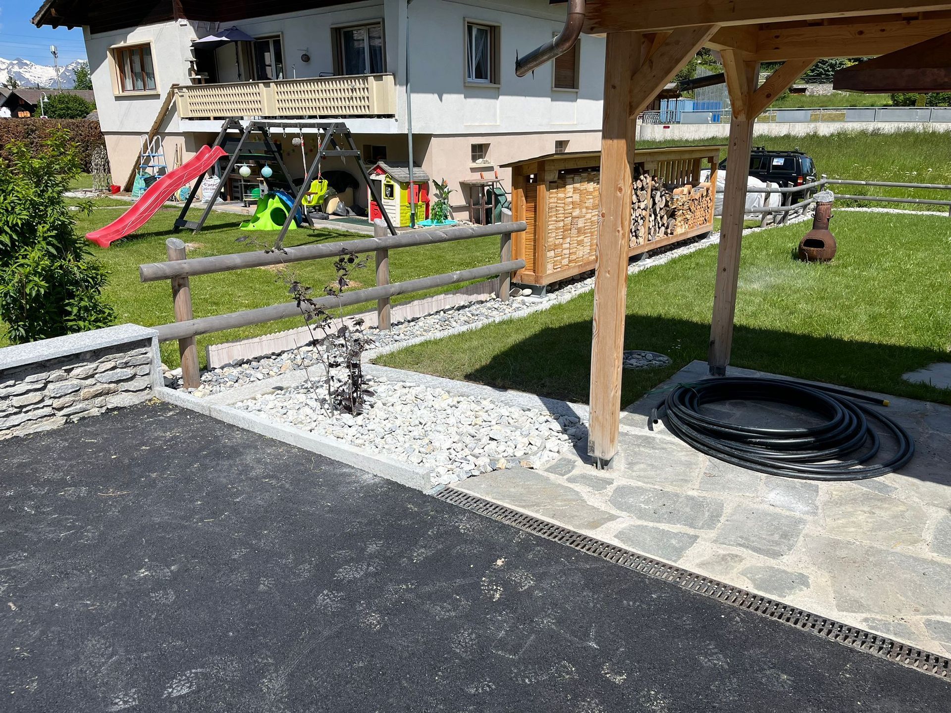 Une maison avec une aire de jeux et une clôture devant.