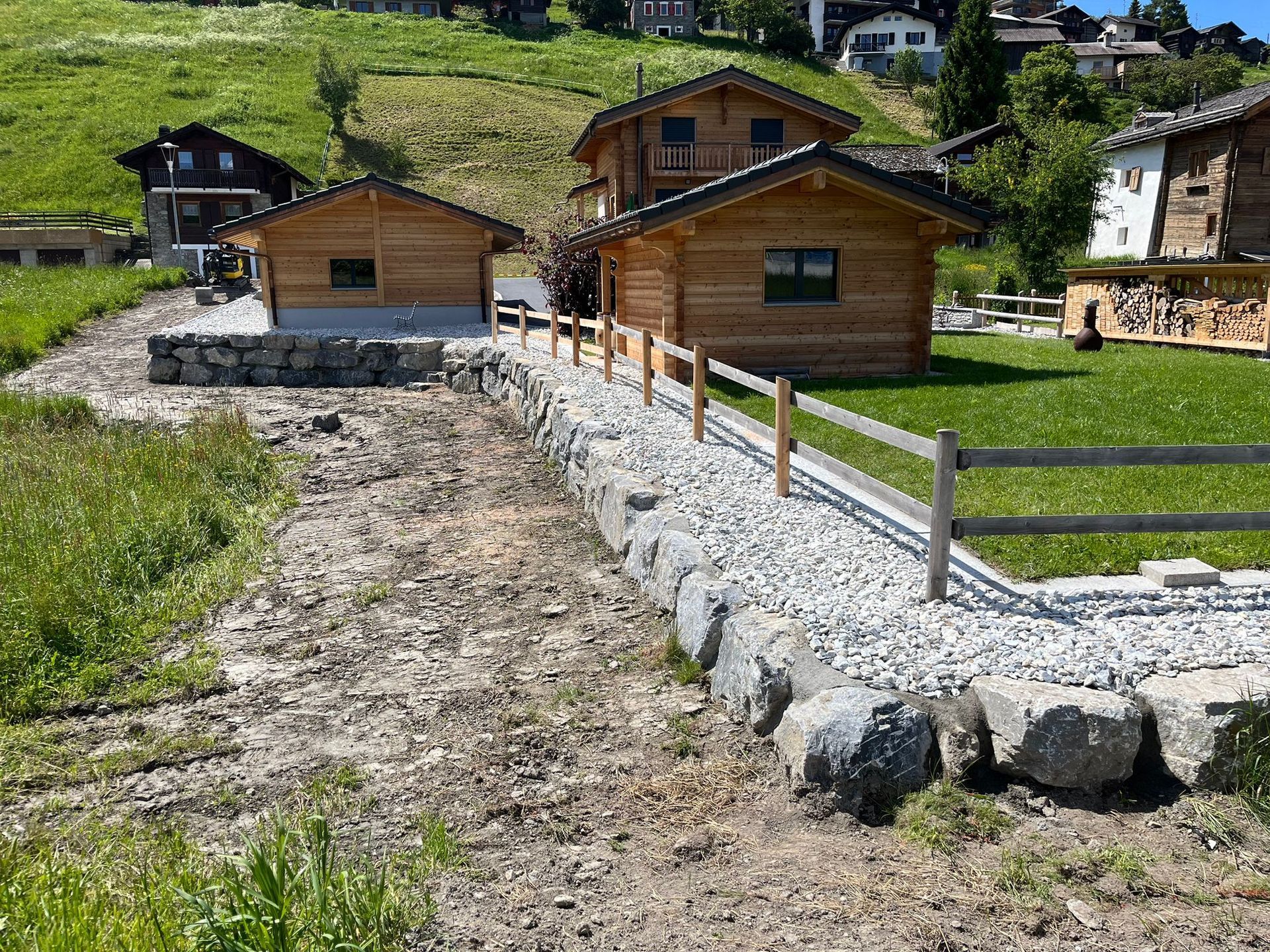 Une maison en bois est assise au milieu d'un champ herbeux.