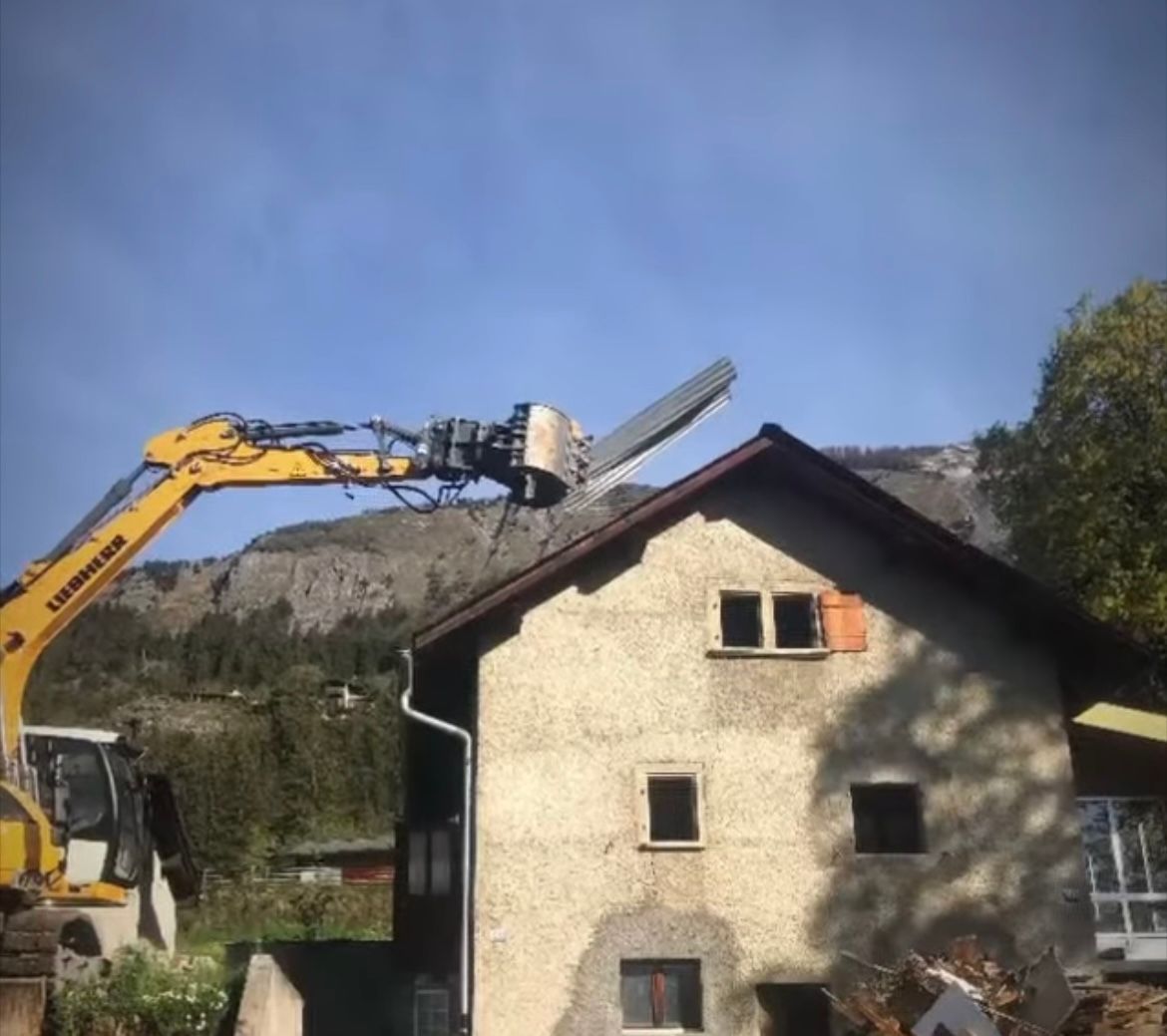 Une pelle Liebherr jaune travaille sur une maison