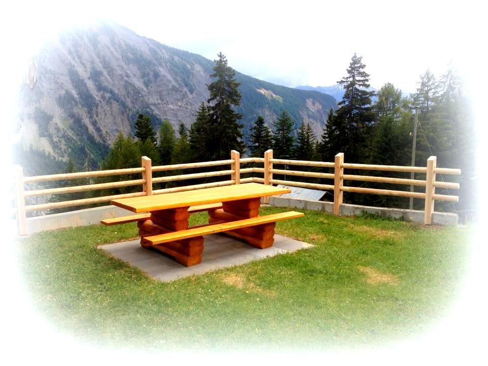 Une table de pique-nique en bois avec une montagne en arrière-plan