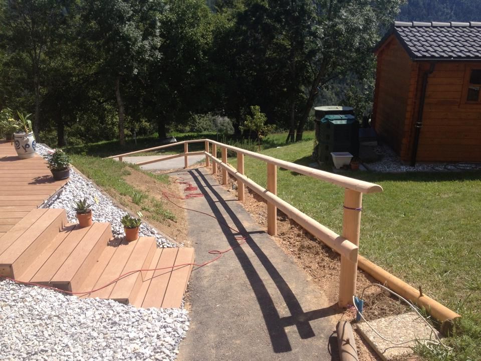 Une clôture en bois entoure une allée menant à une maison