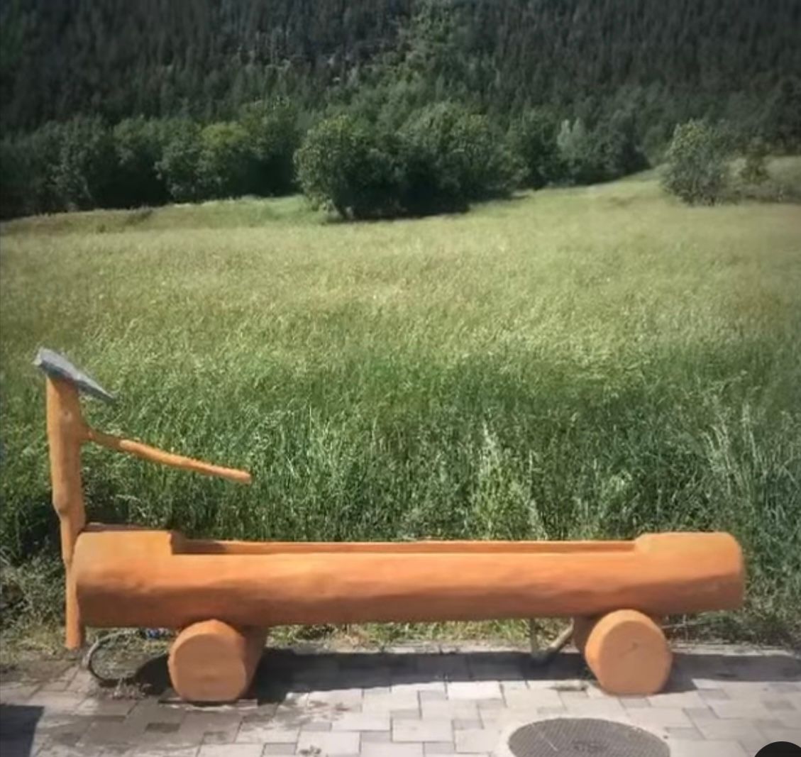 Un banc en bois est assis devant un champ herbeux.