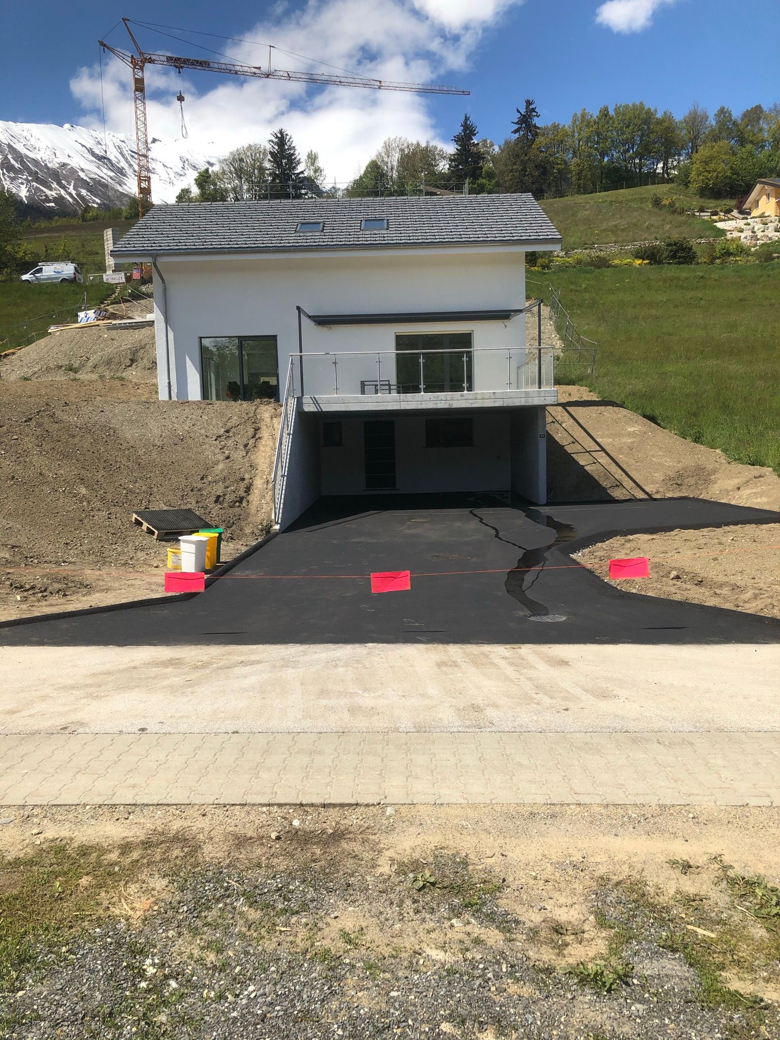 Une maison est en construction sur une colline avec une grue en arrière-plan.
