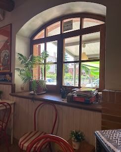 Acogedor interior de restaurante rústico, con manteles blancos, sillas de madera y cálidas lámparas colgantes