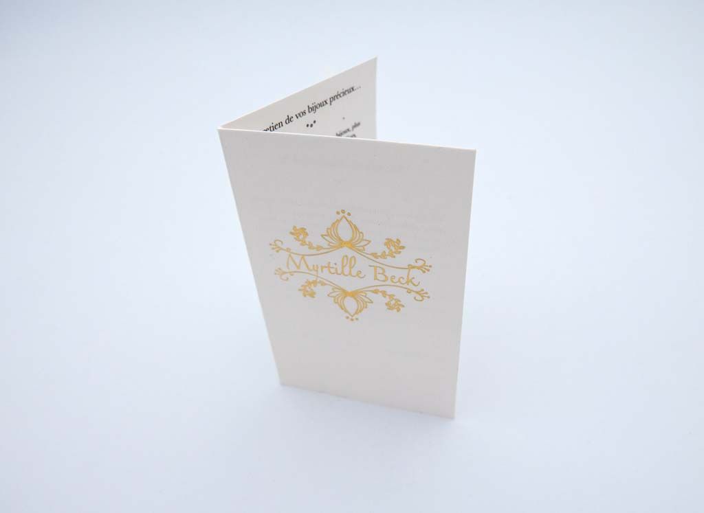 Fascicule de présentation blanc avec motifs dorés sur la couverture pour une créatrice de bijoux