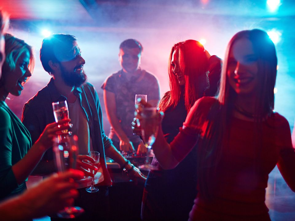Un grupo de personas está bailando y bebiendo champán en una fiesta.
