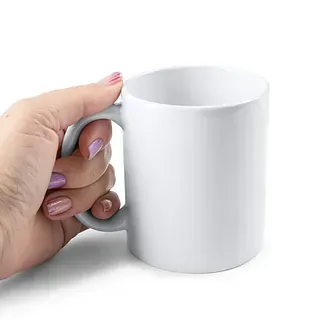Una persona sostiene una taza de café blanca con asa.
