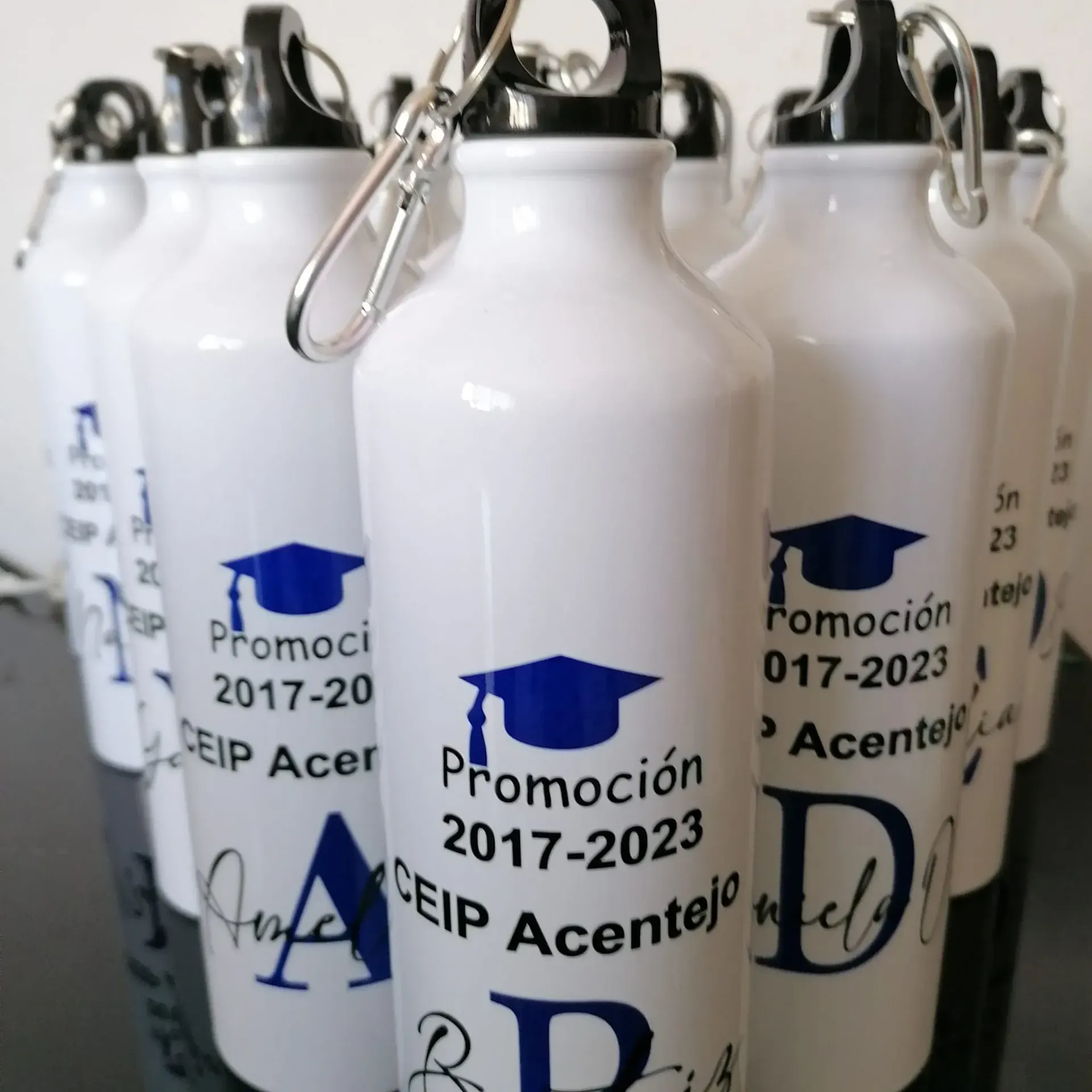 Un montón de botellas de agua con una gorra de graduación en ellas.