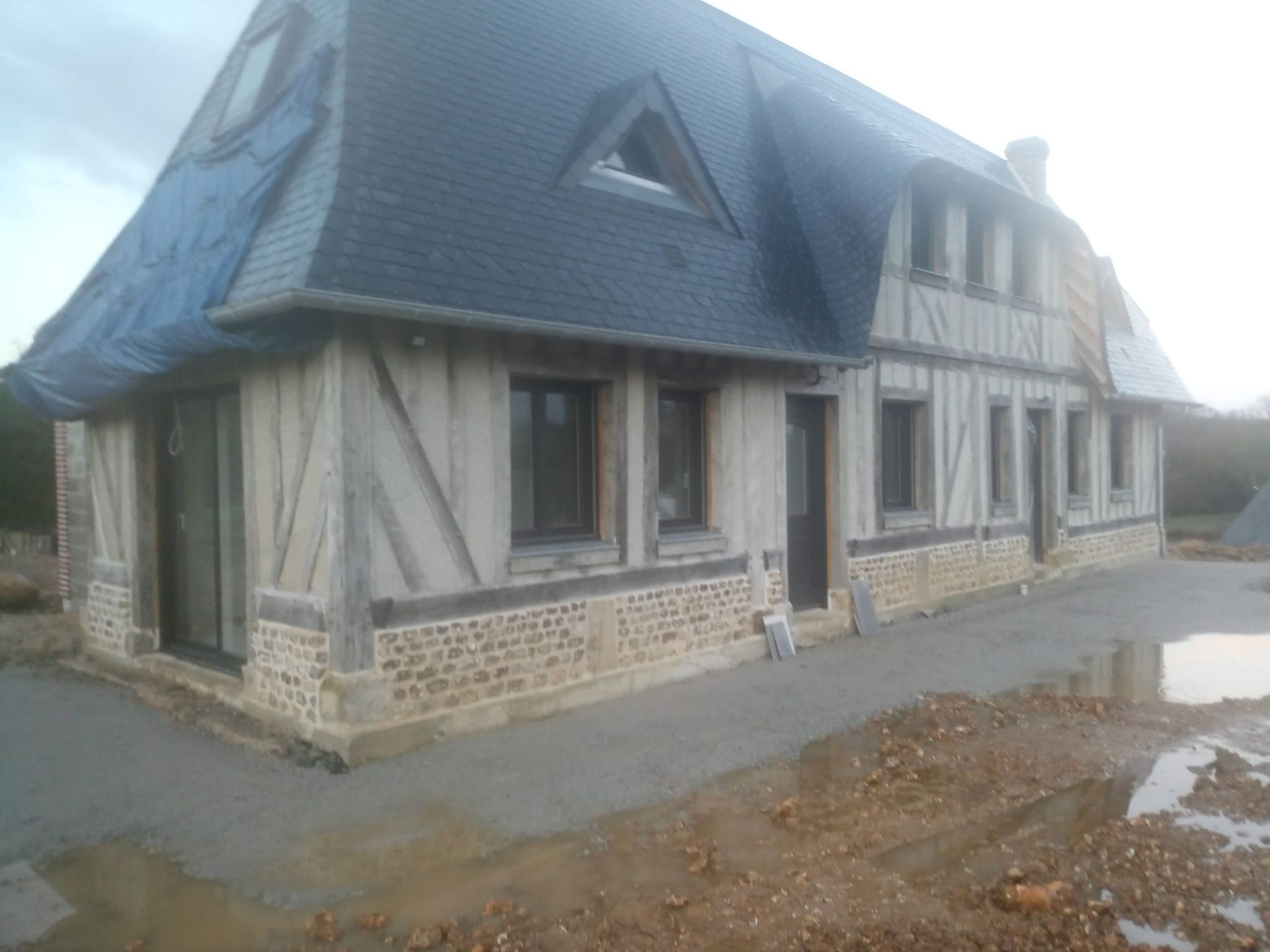 Travaux de soubassement sur une maison à la toiture en ardoises