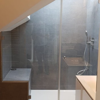 Ein Badezimmer mit ebenerdiger Dusche und Waschbecken