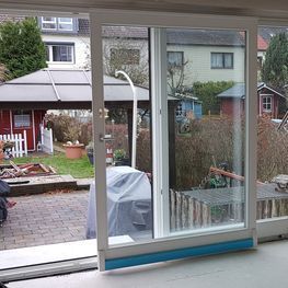 Eine Glasschiebetür mit Blick auf einen Hinterhof.