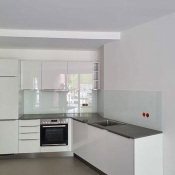 Eine Küche mit weißen Schränken, einer Spüle und einem Herd.