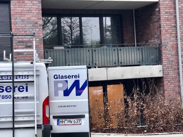 Ein Glaserei-Transporter steht vor einem Backsteingebäude