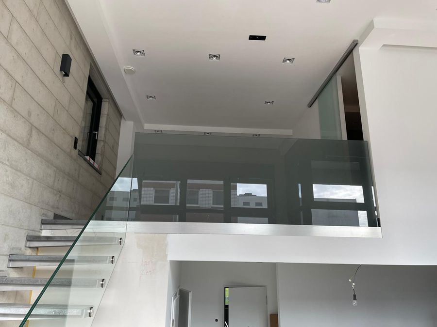 Eine Treppe mit Glasgeländer, die in den zweiten Stock führt