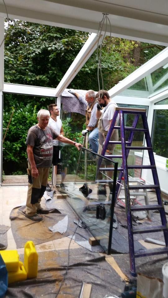 Eine Gruppe Männer arbeitet an einem Glasdach.