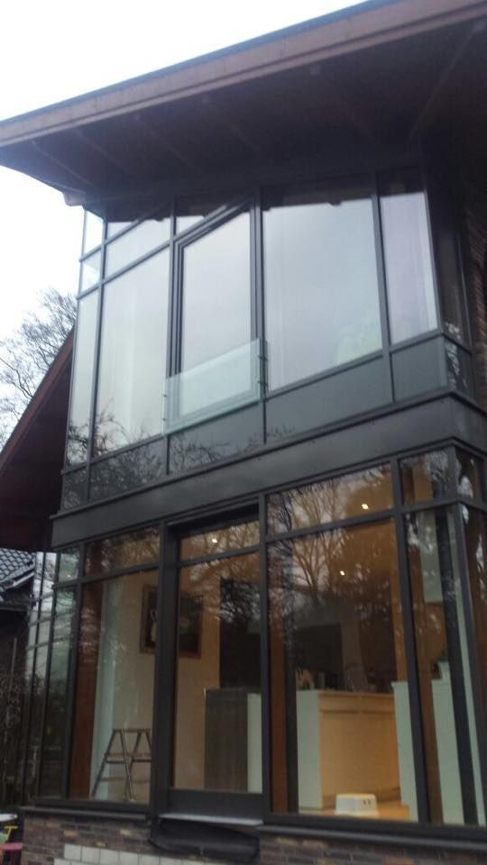 Ein großes Haus mit vielen Fenstern und einem Balkon.