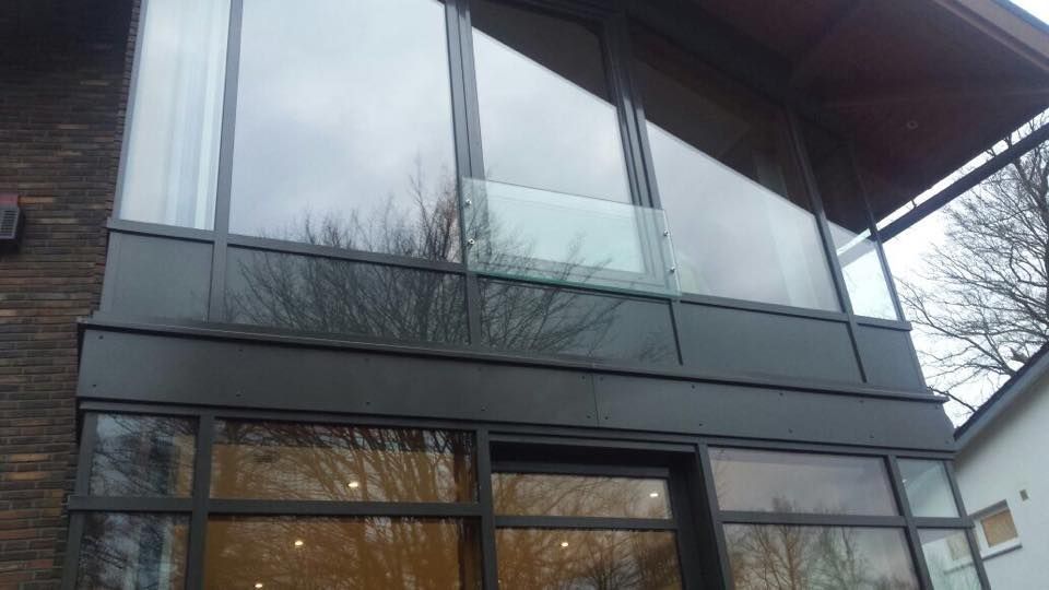 Ein großes Haus mit vielen Fenstern und einem Balkon.