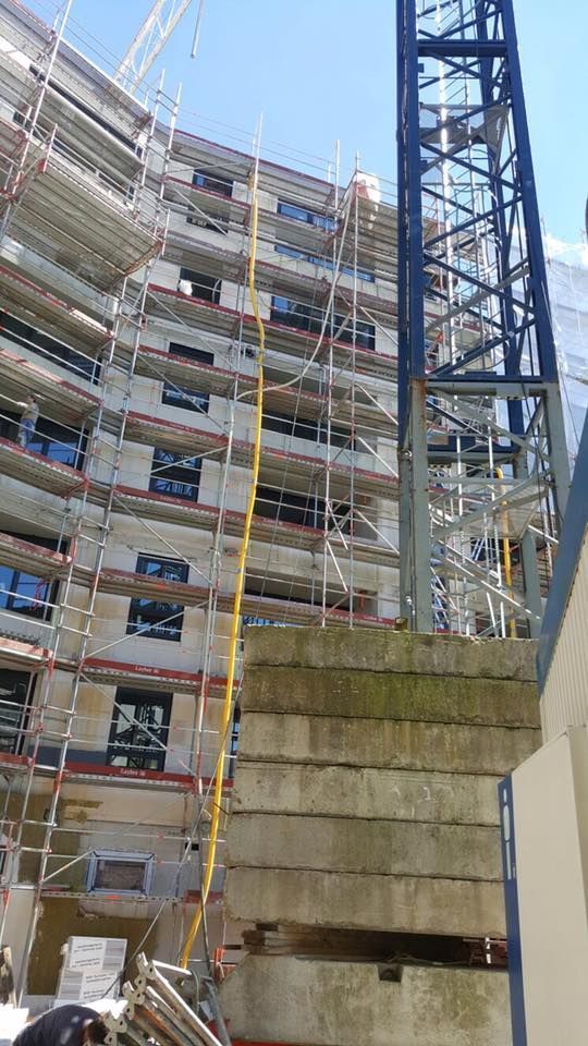 Ein großes Gebäude im Bau mit Gerüst und Kran.