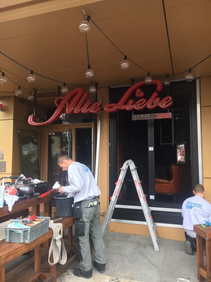 Ein Mann steht vor einem Schild mit der Aufschrift „Alle Liebe“