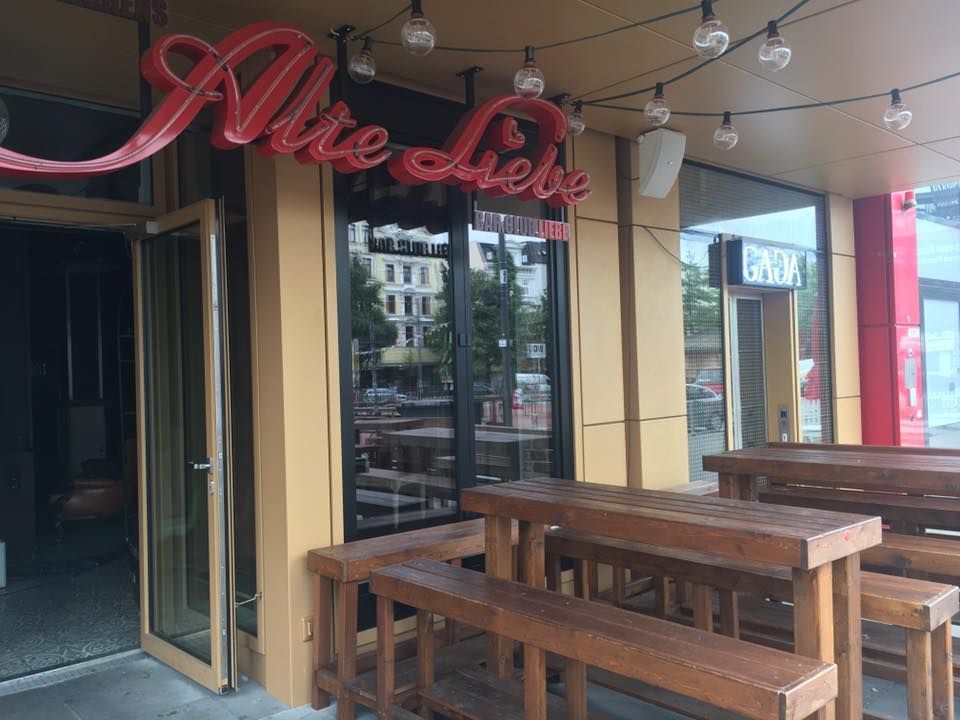 Ein Restaurant mit Holztischen und Bänken davor.