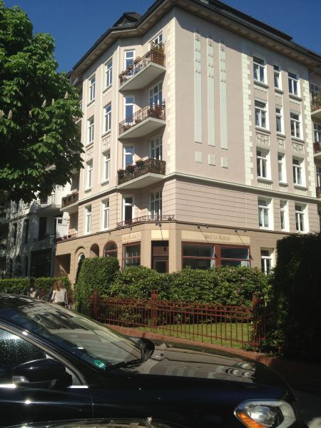 Ein schwarzes Auto parkt vor einem großen Gebäude