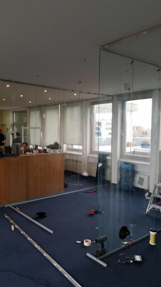 Ein Raum mit vielen Fenstern und einem blauen Teppich.