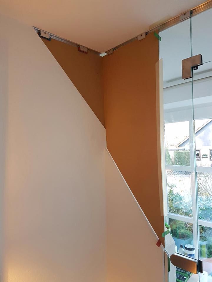 Eine Raumecke mit einer Glastür und einem Fenster.