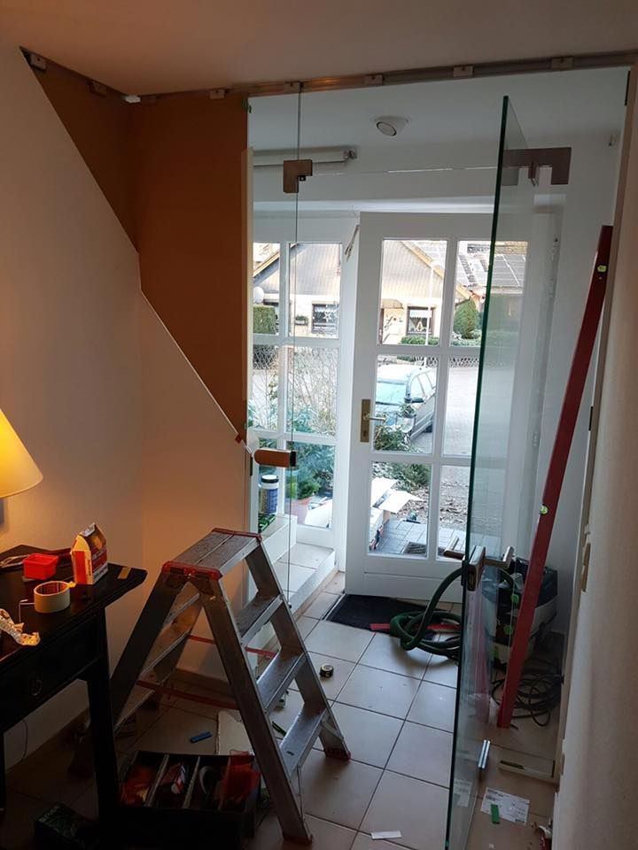 In einem Raum neben einer Tür steht eine Leiter.