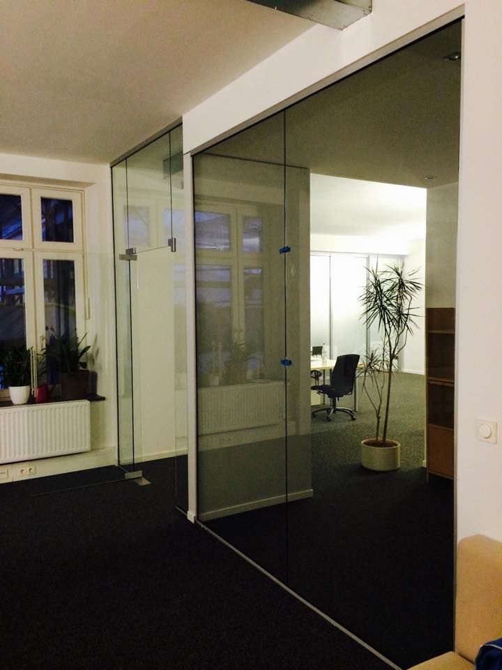 Ein Raum mit einer Glaswand und einer Pflanze in einem Topf