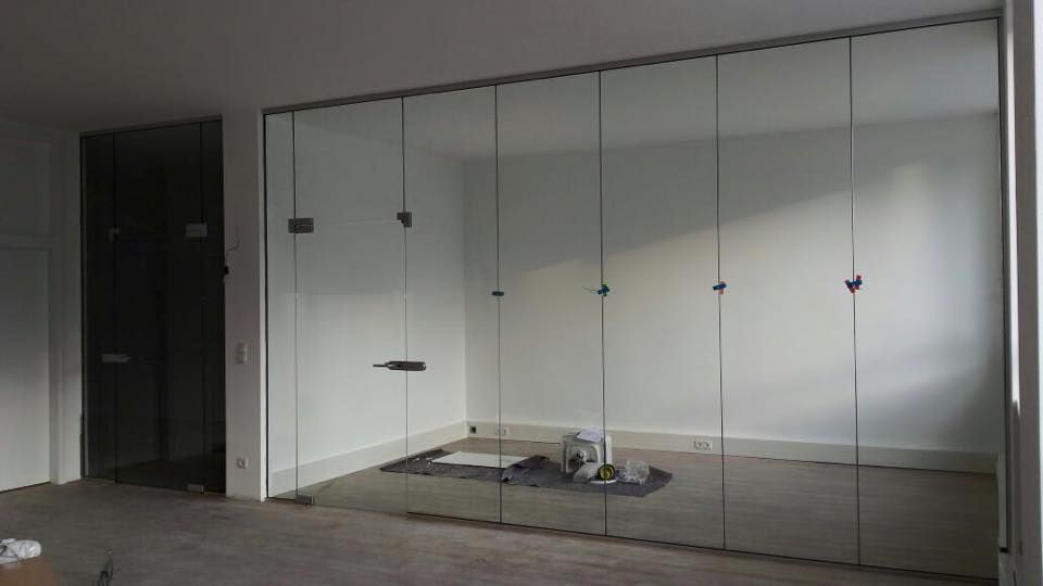 Ein Raum mit vielen Glaswänden und einer Tür.