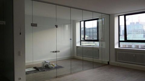 Ein leerer Raum mit Glasschiebetüren und Fenstern.