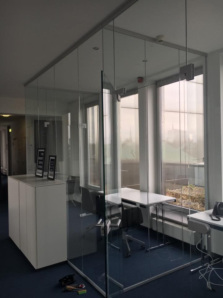 Ein Raum mit vielen Fenstern und einer Glaswand