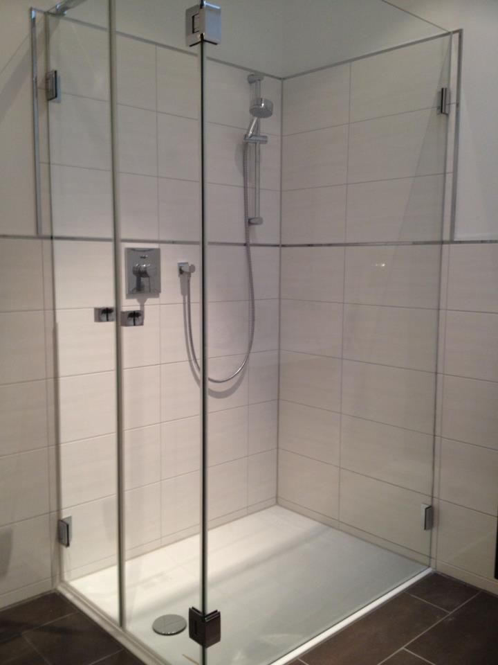 Eine Duschkabine mit Glastür und Duschkopf