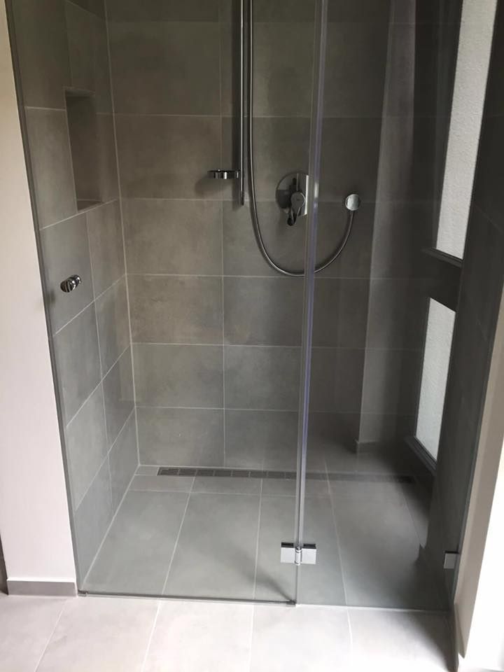 Ein Badezimmer mit ebenerdiger Dusche mit Glastür.