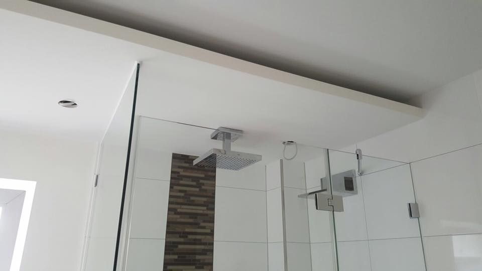 Ein Badezimmer mit ebenerdiger Dusche und Deckenleuchte