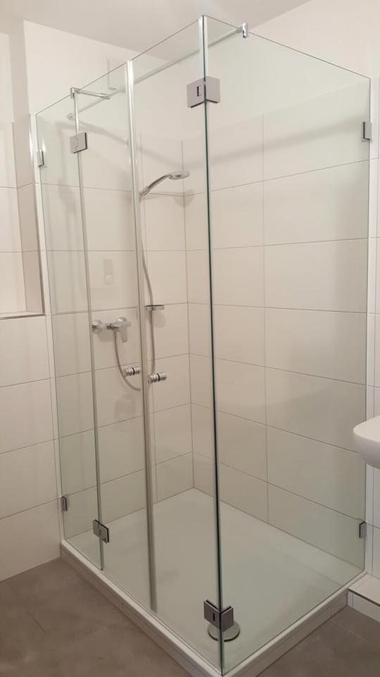 Ein Badezimmer mit Duschkabine und Waschbecken.