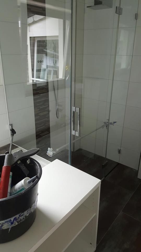 Ein Badezimmer mit Waschbecken und Dusche mit Glastür.