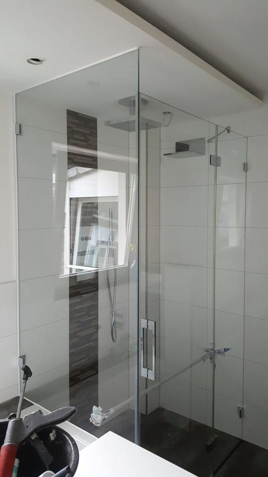 Ein Badezimmer mit Glasduschtür und Waschbecken.