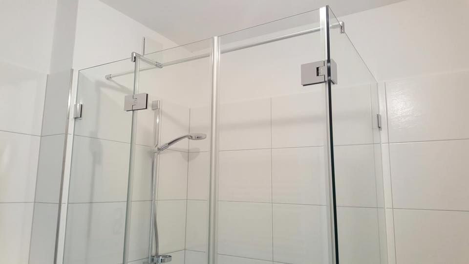 Ein Badezimmer mit Duschkabine und Duschkopf.