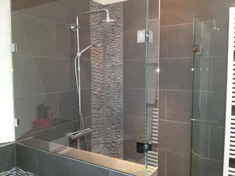 Ein Badezimmer mit Glasduschtür und Handtuchhalter.