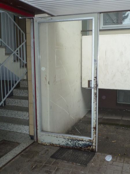 Eine Tür mit einem Spiegel darauf und einer Treppe dahinter